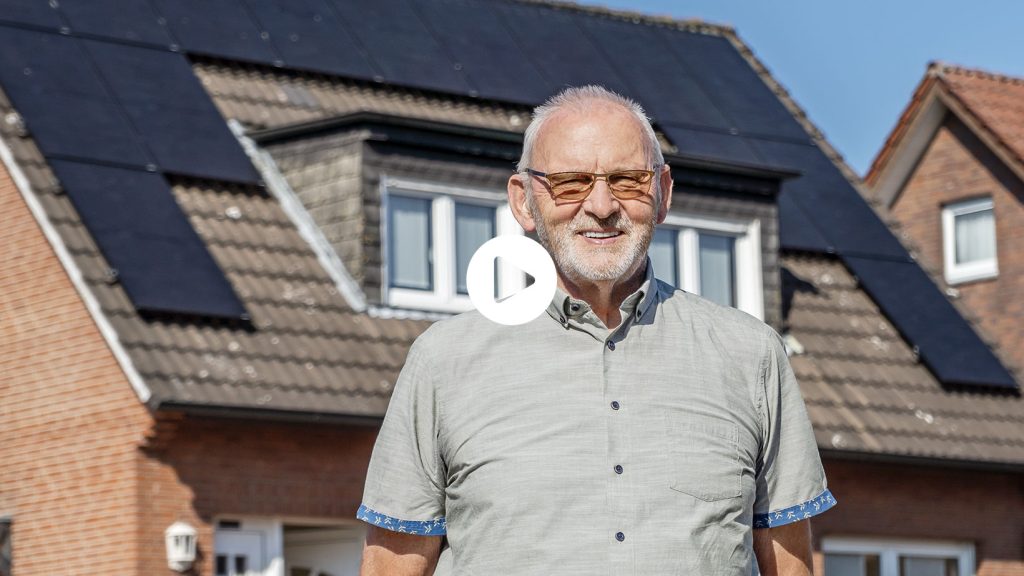 Herr Haarmann posiert vor seinem Haus mit neuer Photovoltaikanlage