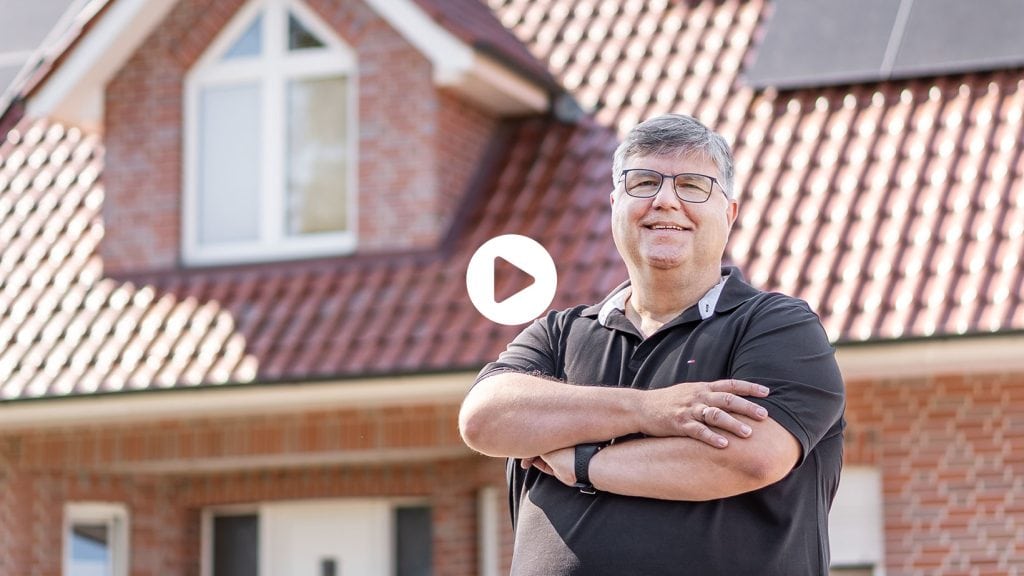 Herr Höppe posiert vor seinem Haus mit neuer Photovoltaikanlage